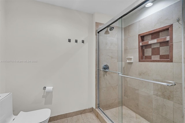 full bathroom with baseboards, toilet, and a stall shower