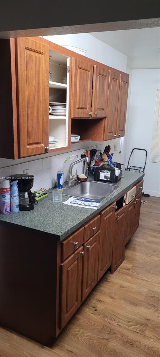 kitchen with sink, decorative backsplash, and light wood-type flooring