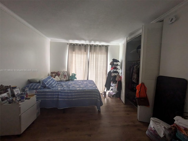 bedroom with ornamental molding, dark wood-type flooring, and a closet