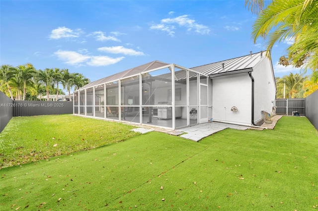 back of house with a patio, glass enclosure, and a lawn