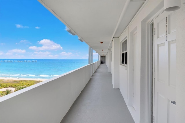 balcony featuring a beach view and a water view