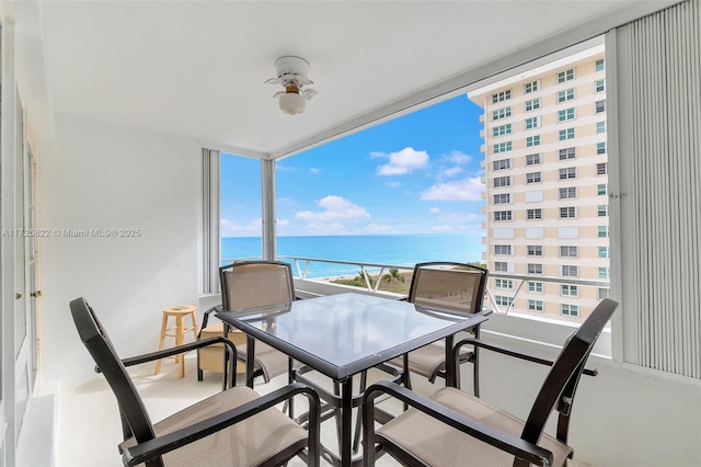 balcony with ceiling fan and a water view