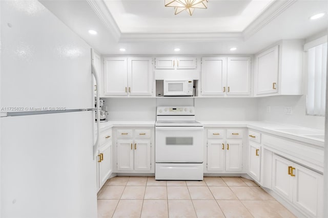 kitchen featuring white appliances, white cabinets, and a tray ceiling