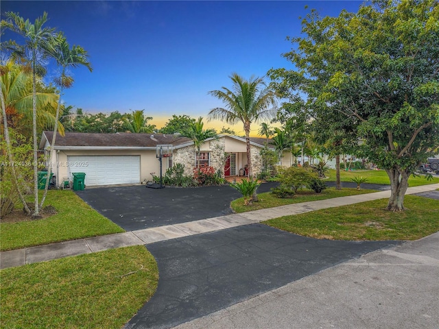 view of front of home with a yard and a garage