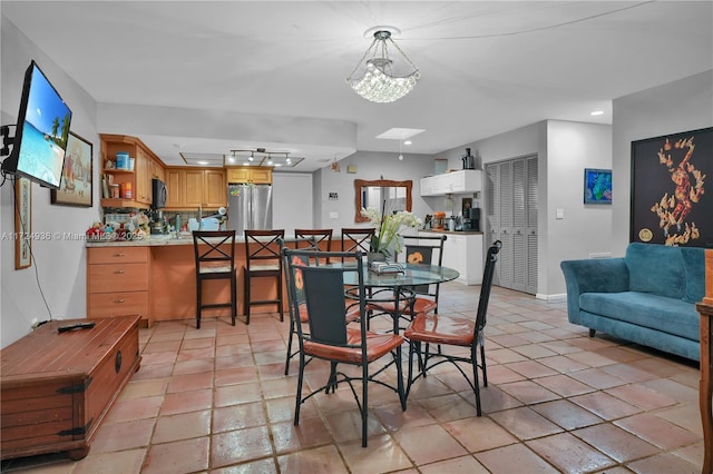 dining room featuring a skylight and light tile patterned floors