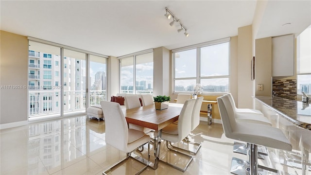 dining area with light tile patterned floors and a wall of windows