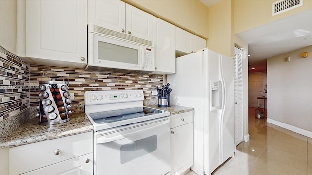 kitchen featuring white appliances, white cabinetry, light tile patterned floors, backsplash, and light stone counters