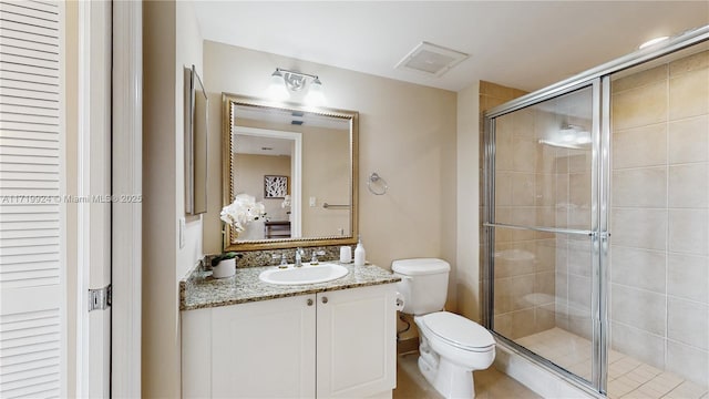 bathroom featuring vanity, toilet, and a shower with door