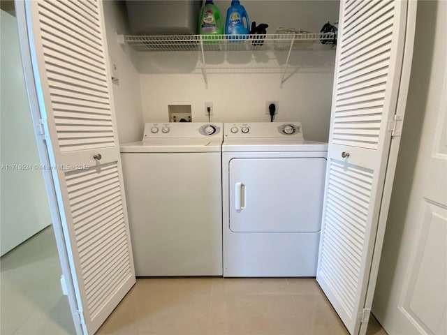 laundry room featuring washing machine and dryer and light tile patterned floors