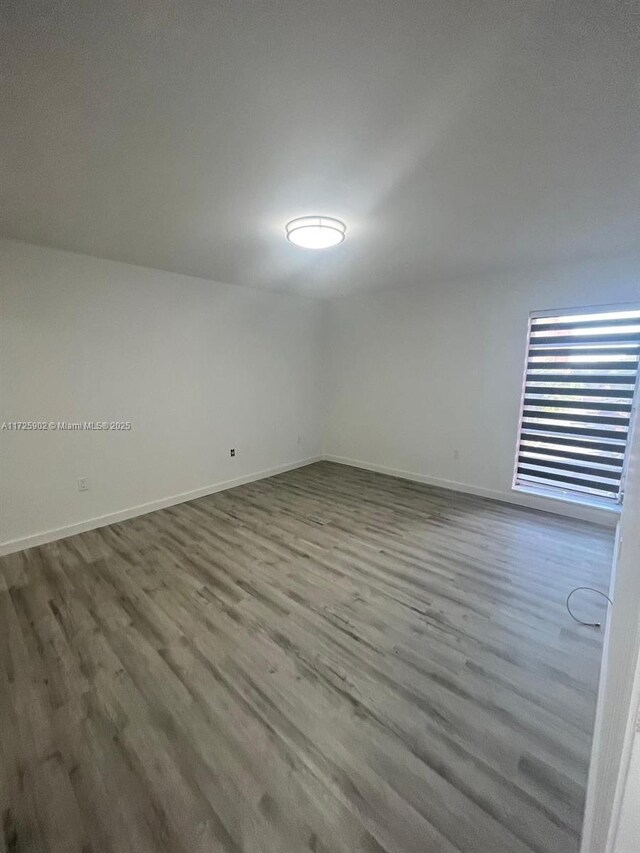 unfurnished room with wood-type flooring