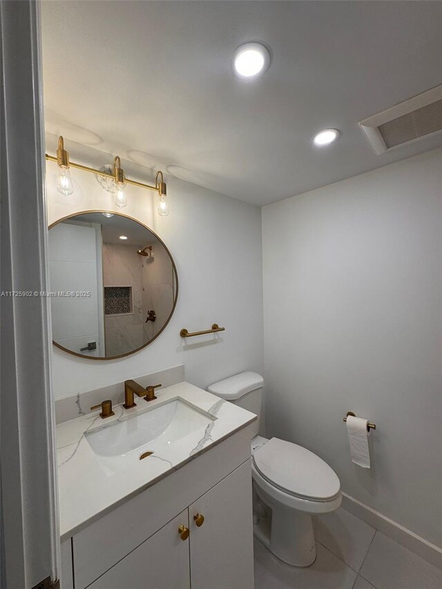 bathroom featuring toilet, vanity, and tile patterned flooring