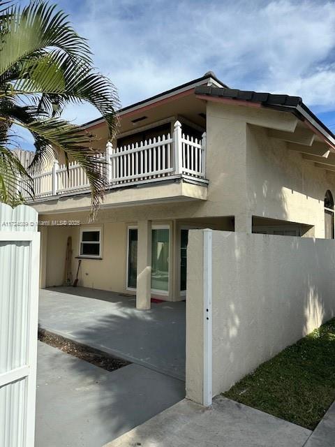 view of side of property with a balcony and a patio area