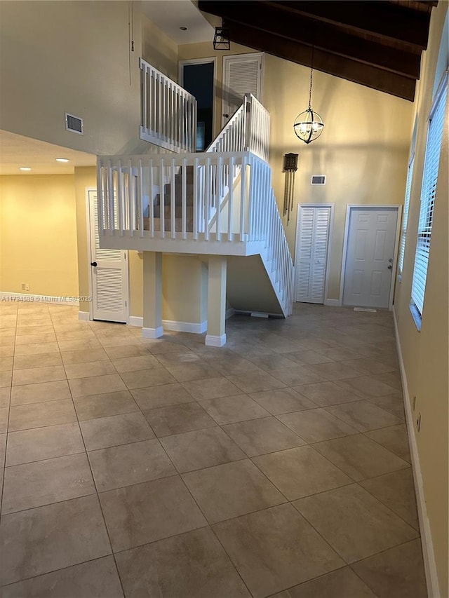 stairs featuring high vaulted ceiling, beam ceiling, and tile patterned flooring