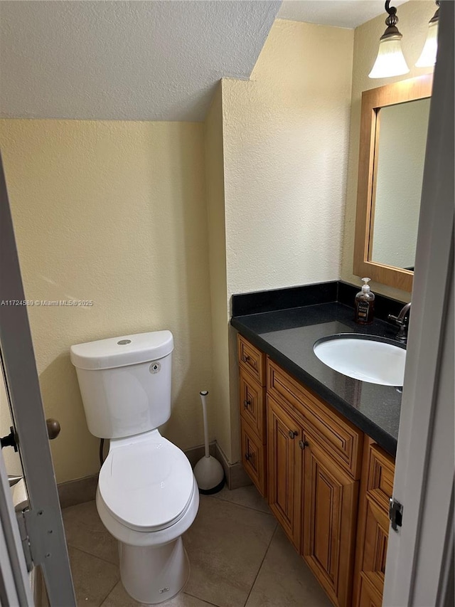 bathroom featuring a textured ceiling, tile patterned floors, vanity, and toilet