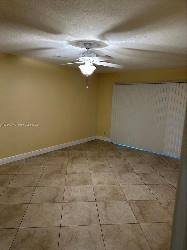 tiled spare room featuring ceiling fan and a textured ceiling