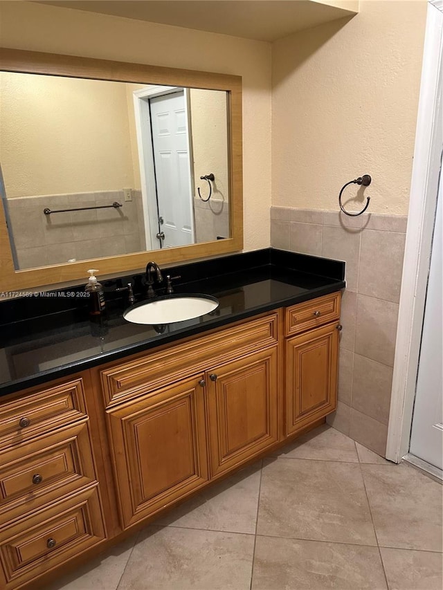 bathroom with tile patterned flooring, tile walls, and vanity