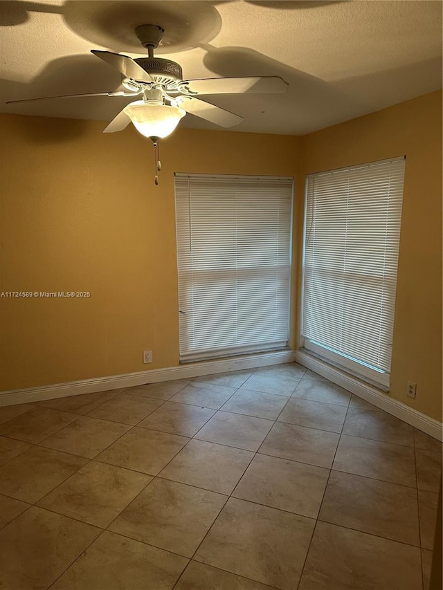 spare room featuring ceiling fan and light tile patterned floors