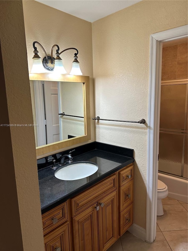 full bathroom with toilet, tile patterned floors, vanity, and enclosed tub / shower combo