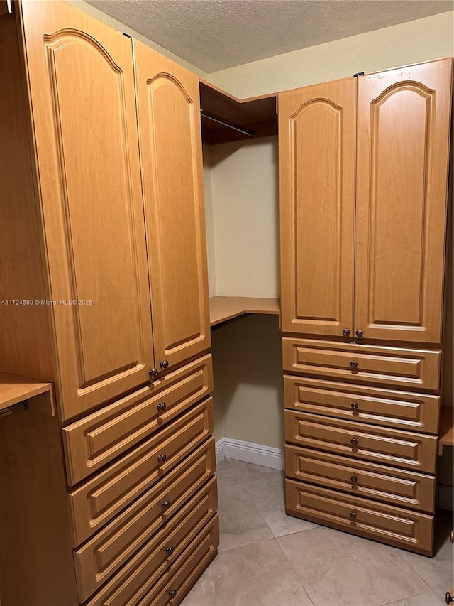 spacious closet with light tile patterned flooring