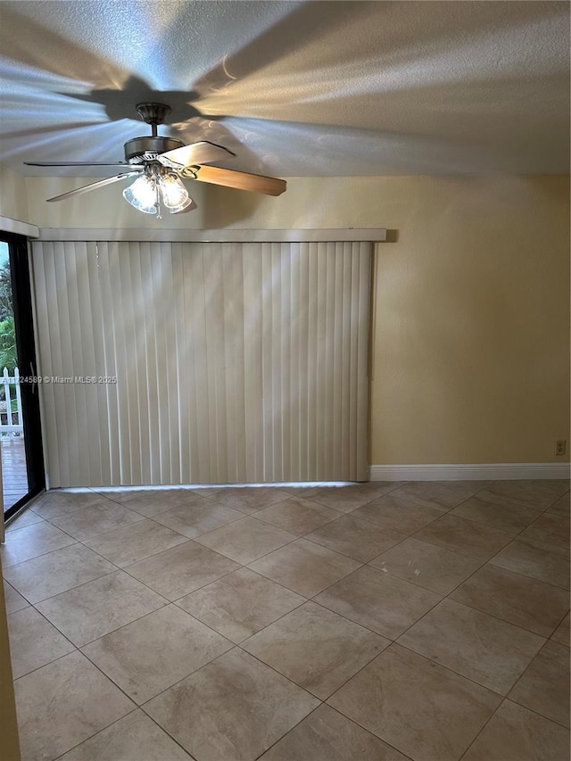 unfurnished room with a textured ceiling, ceiling fan, and light tile patterned floors