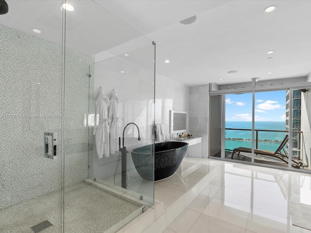 bathroom featuring tile patterned flooring, a water view, plus walk in shower, and expansive windows