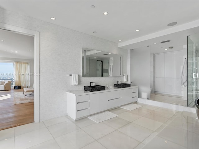 bathroom featuring vanity, a shower with door, and tile patterned flooring