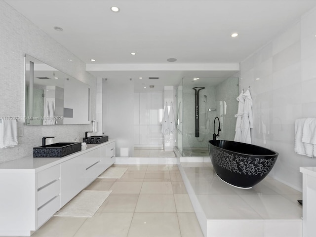 bathroom with tile walls, tile patterned flooring, plus walk in shower, and vanity