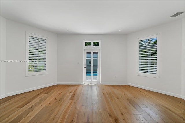 spare room featuring french doors and light hardwood / wood-style flooring