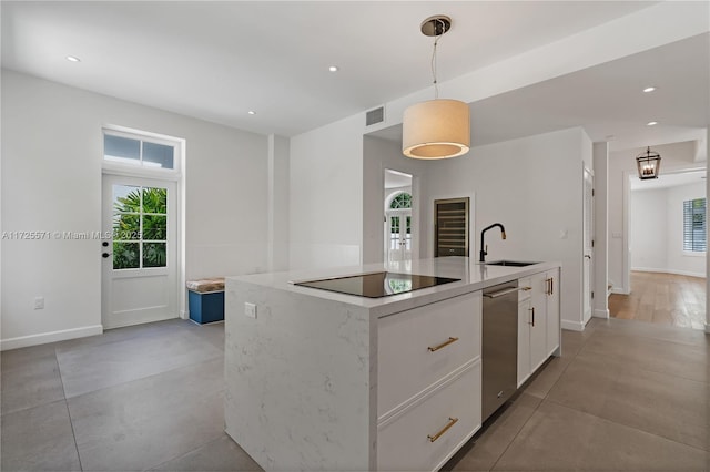 kitchen featuring sink, white cabinetry, hanging light fixtures, a center island with sink, and black electric cooktop