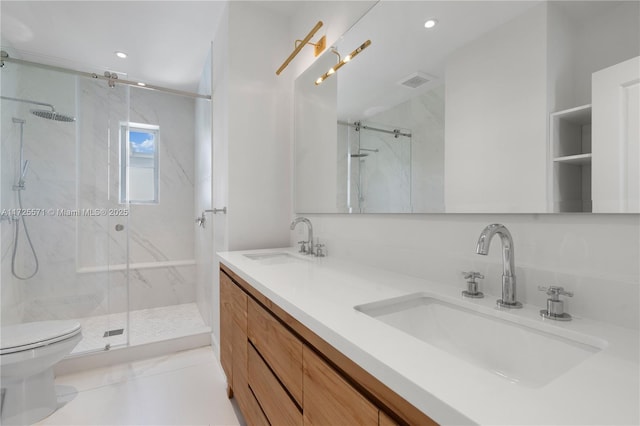 bathroom featuring tile patterned flooring, vanity, toilet, and walk in shower