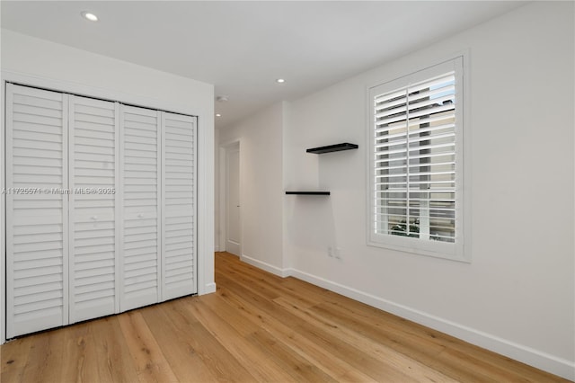 unfurnished bedroom featuring light wood-type flooring and a closet