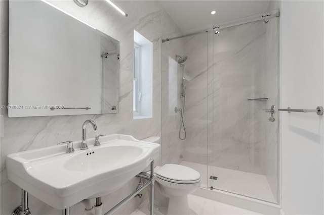 bathroom featuring a shower with door, sink, tile walls, and toilet