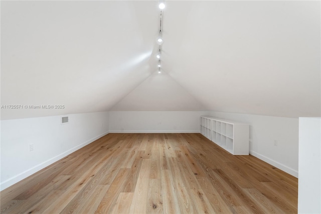 additional living space with lofted ceiling and light hardwood / wood-style floors