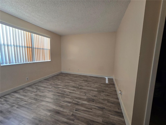 empty room featuring a textured ceiling and wood-type flooring