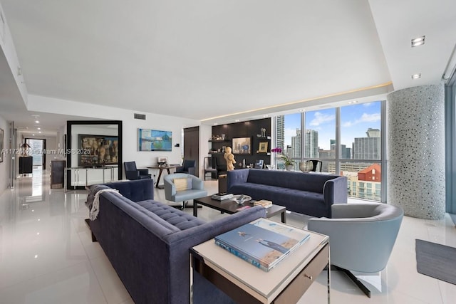 living room with a view of city, light tile patterned floors, a wall of windows, and visible vents