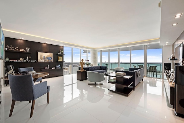 living room featuring plenty of natural light, a water view, light tile patterned flooring, and floor to ceiling windows