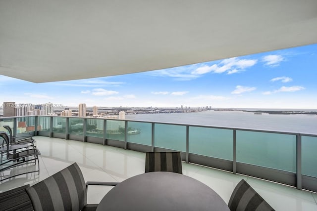 balcony featuring a water view and a city view