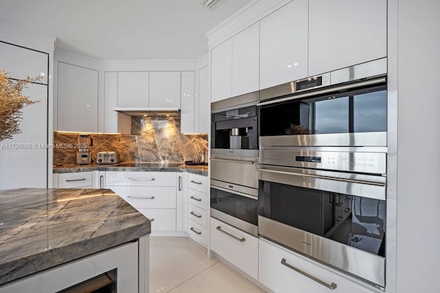 kitchen with double oven, modern cabinets, dark stone counters, and white cabinets