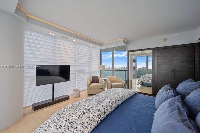 bedroom featuring access to exterior, light wood-type flooring, and recessed lighting