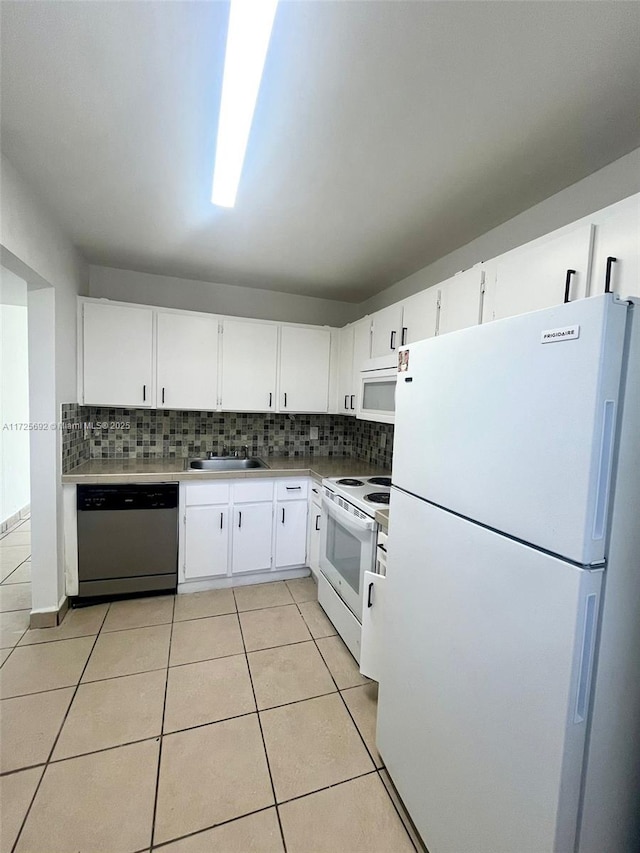 kitchen featuring sink, white cabinetry, white appliances, light tile patterned flooring, and tasteful backsplash