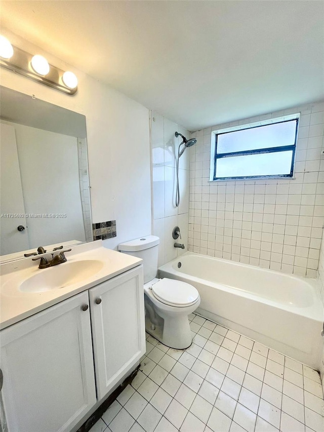 full bathroom featuring toilet, tiled shower / bath combo, tile patterned floors, and vanity