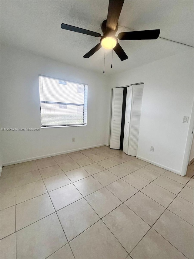 unfurnished bedroom featuring ceiling fan and light tile patterned floors