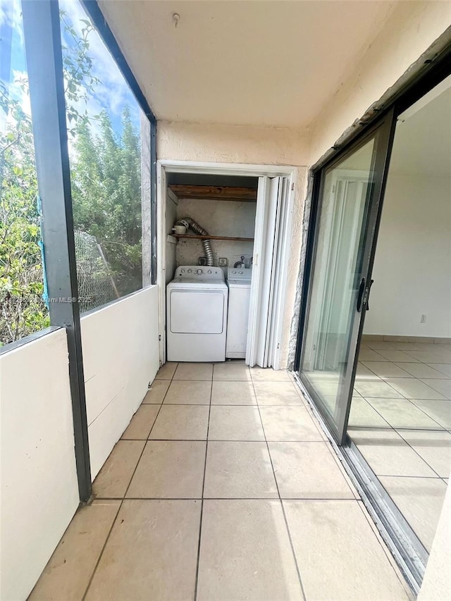 washroom with washing machine and dryer and light tile patterned flooring