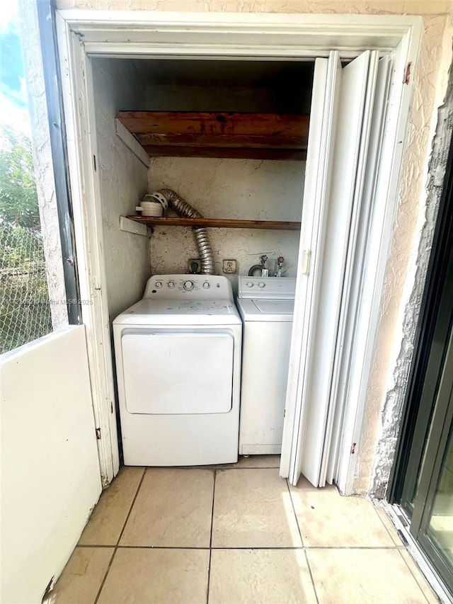 washroom featuring washing machine and clothes dryer and light tile patterned floors