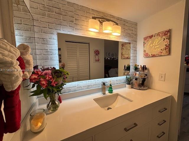 bathroom with brick wall and vanity