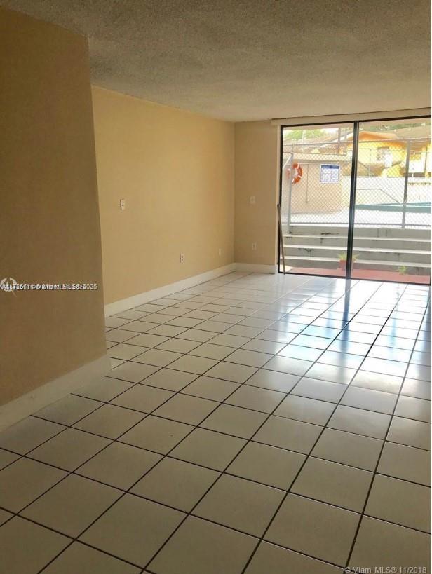 unfurnished room featuring a wall of windows, light tile patterned floors, and a textured ceiling