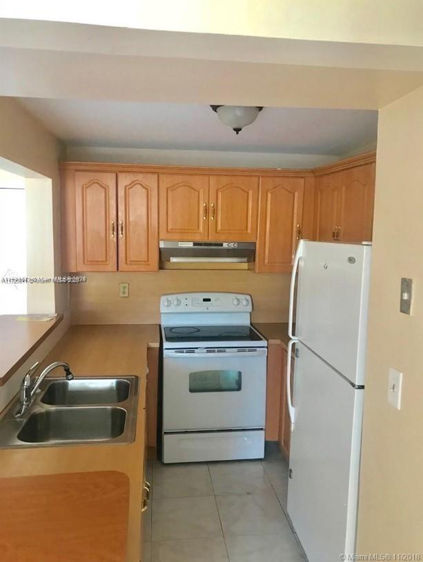 kitchen with light tile patterned floors, sink, and white appliances