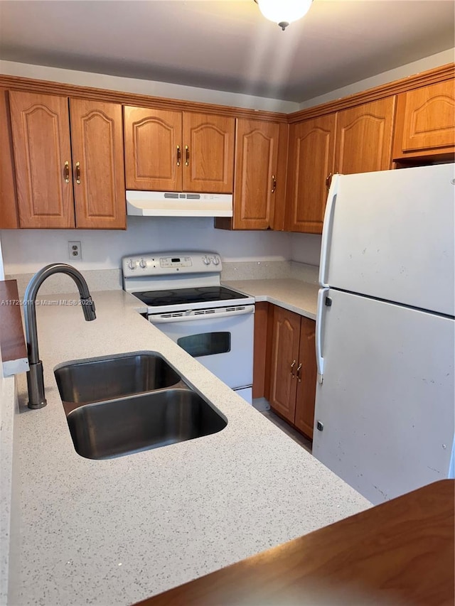 kitchen featuring a sink, brown cabinets, white appliances, and under cabinet range hood