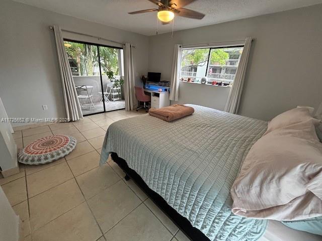 bedroom featuring ceiling fan, access to exterior, and light tile patterned floors