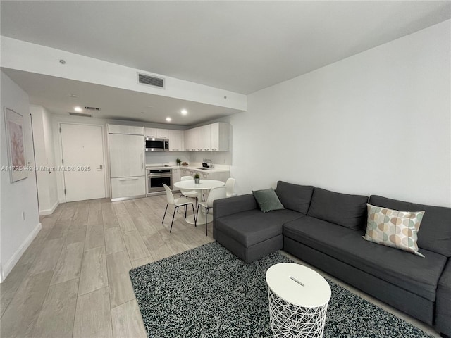 living room with sink and light hardwood / wood-style floors